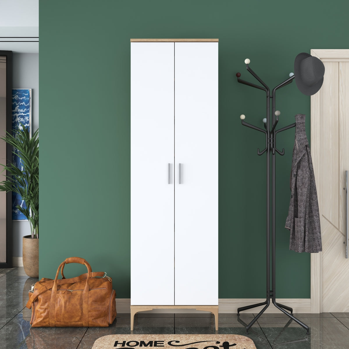 A tall white two-door wardrobe or cabinet with light wood top and bottom trim, shown in a styled room with a green wall, coat rack, hat, brown duffel bag, and a doormat.