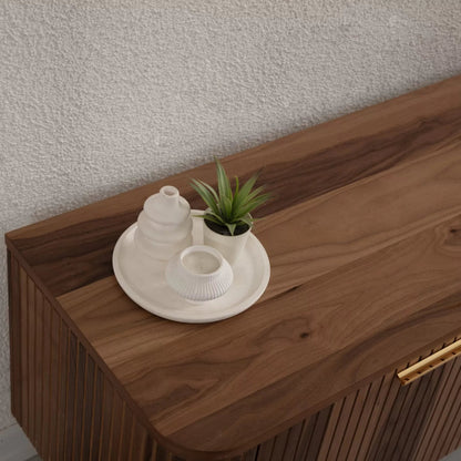 Asta Wooden Fire TV Unit 200cm. High-angle close-up of the smooth, rounded corner and rich brown walnut wood top of the TV unit, styled with a small white tray holding a miniature potted succulent and white ceramic vases. The image highlights the natural wood grain and quality surface for displaying decor.