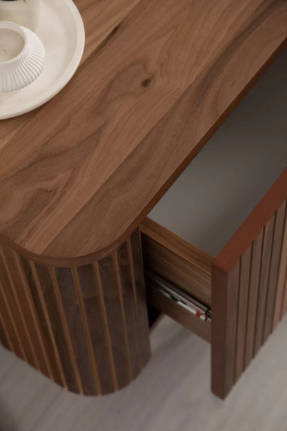 Asta Wooden Fire TV Unit 200cm. High-angle close-up view showing the rich brown walnut wood top and rounded, slatted side of the TV unit with a drawer partially pulled out. The exposed drawer reveals smooth slides and light gray interior, demonstrating the unit's quality construction and hidden storage capacity.