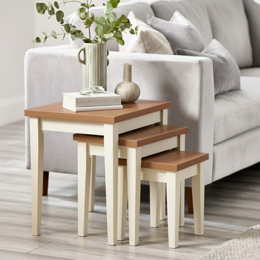 Set of nesting tables with wooden tops and white bases in a living room setting.