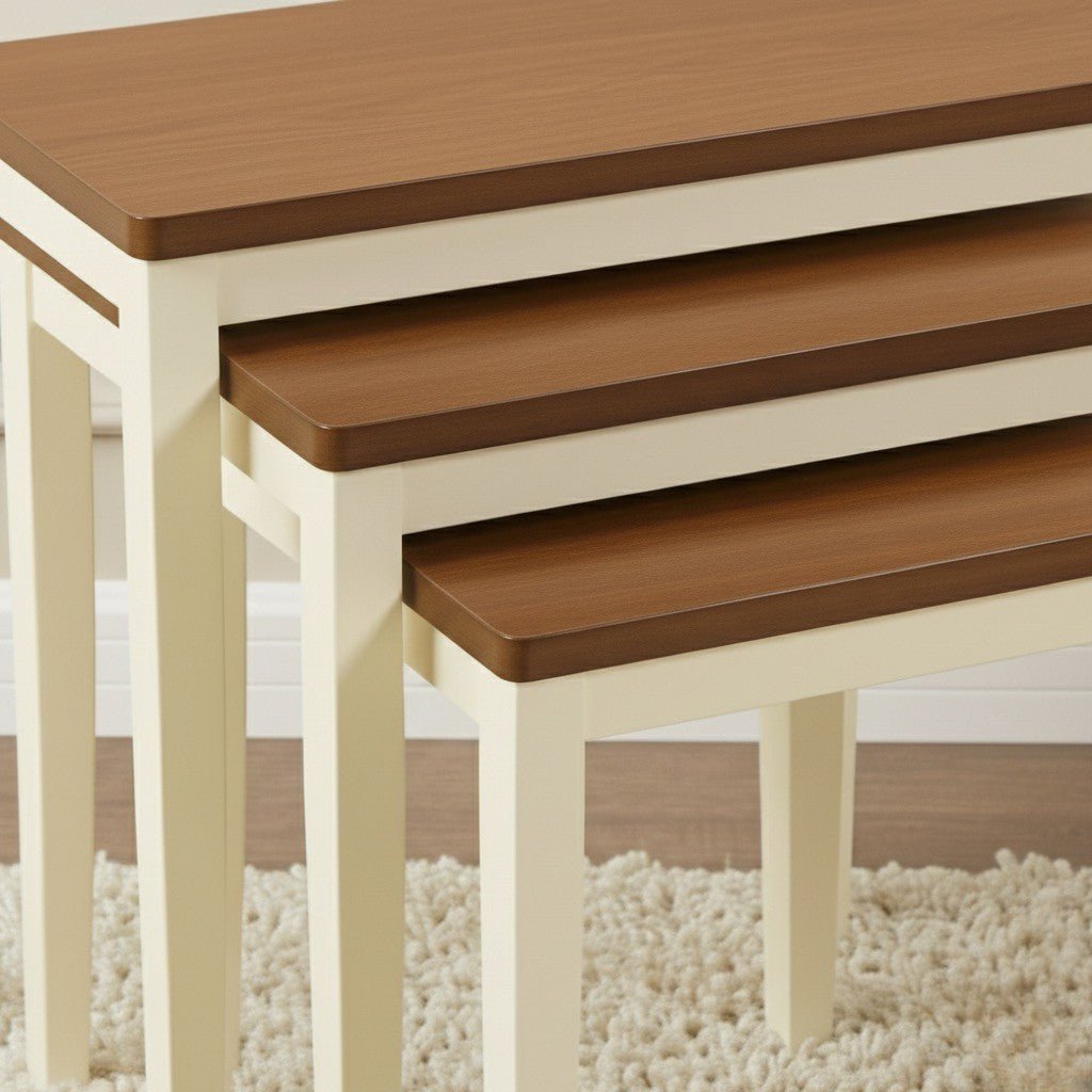 Set of three wooden nesting tables with beige legs on a carpeted floor.