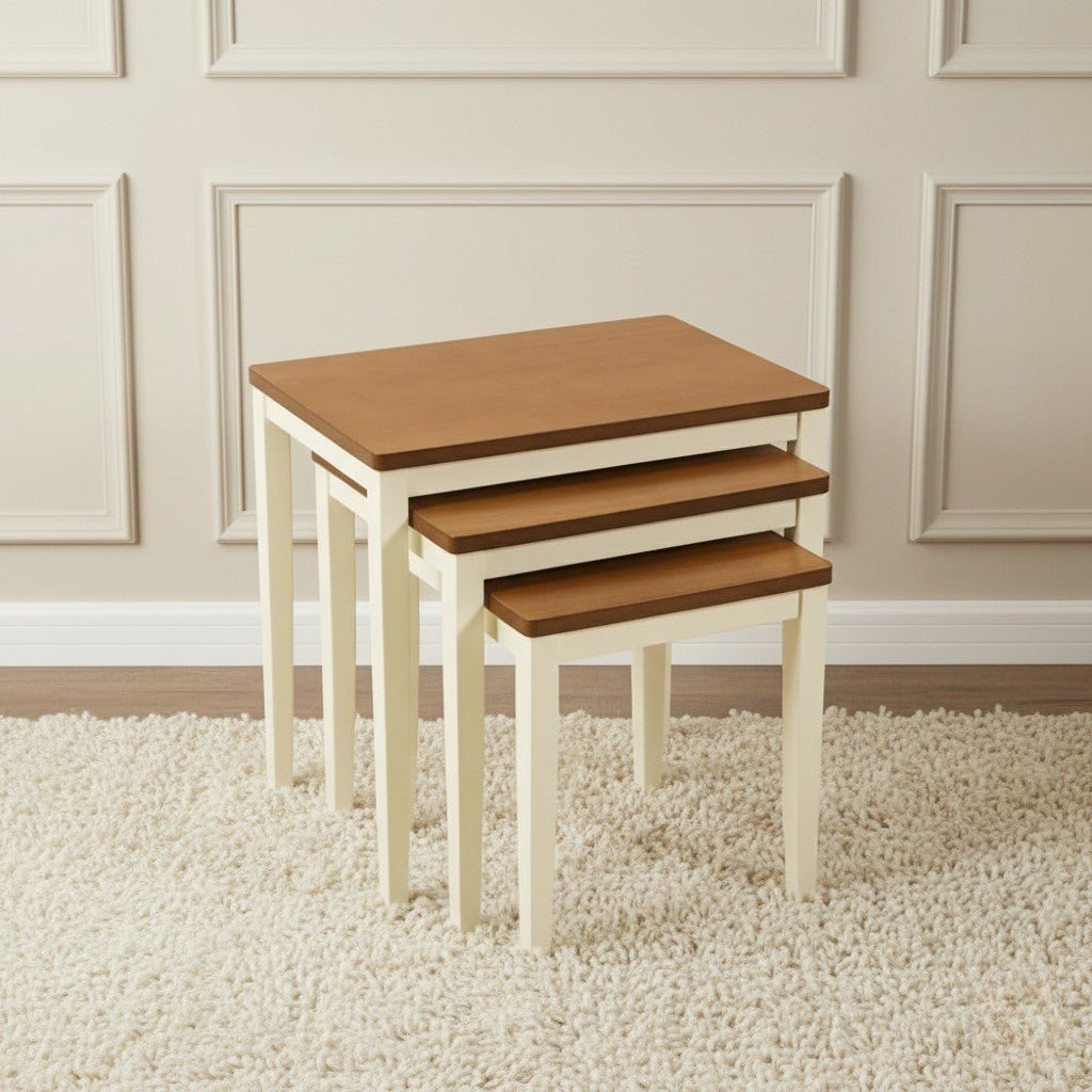 Set of three wooden nesting tables in a room with beige walls and carpet.