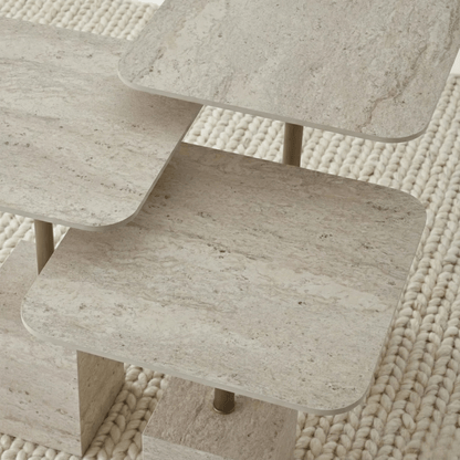 Close-up of a textured travertine tables top against a woven beige background