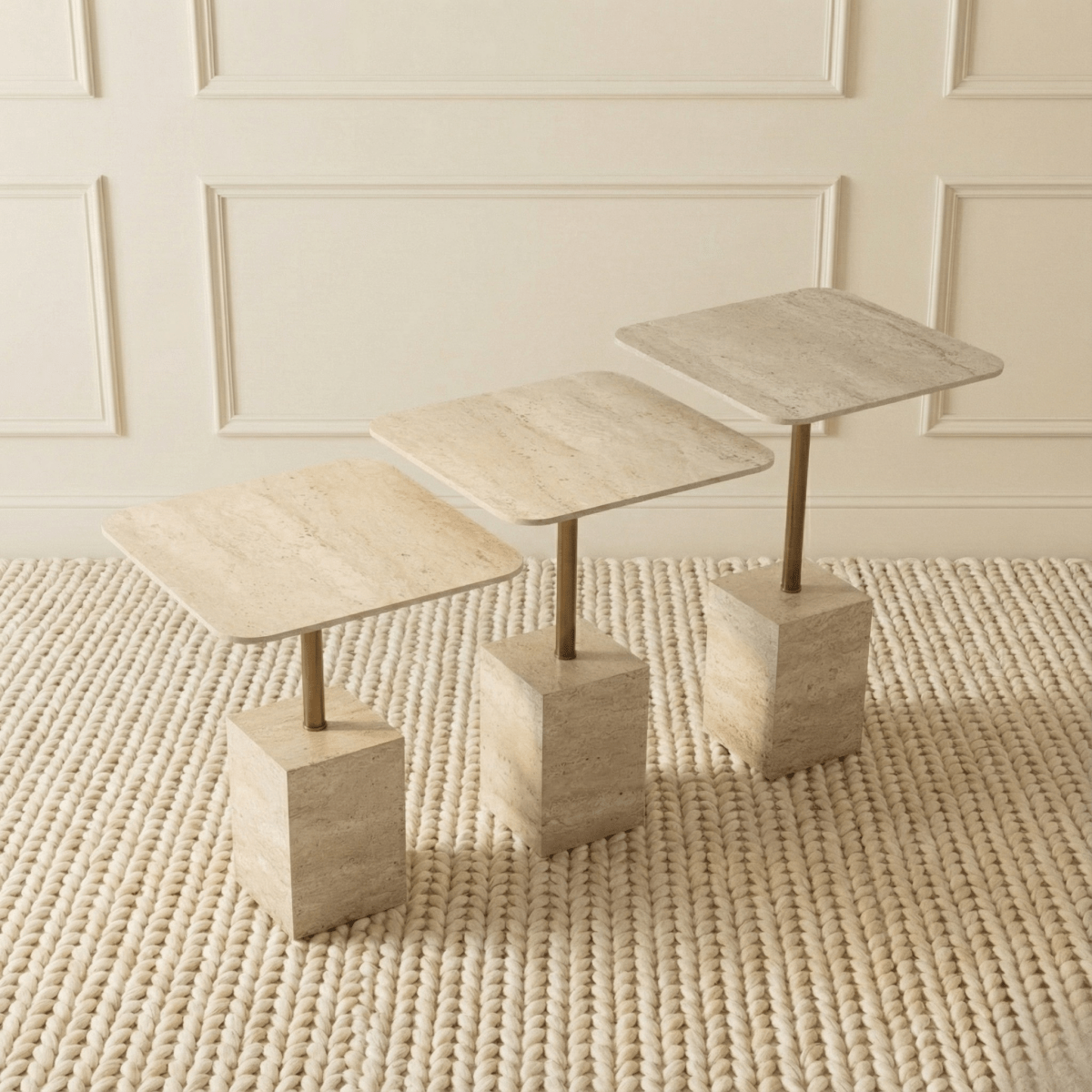 Set of three stone-effect side tables on a textured rug with a neutral wall background