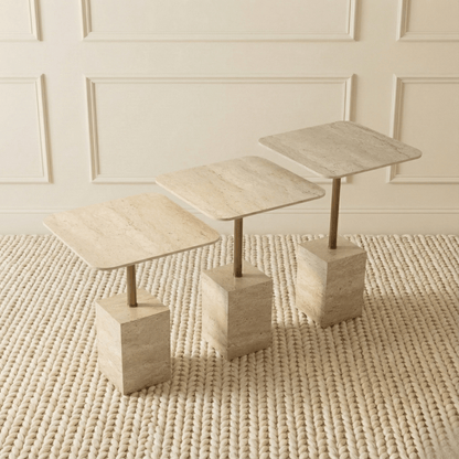 Set of three stone-effect side tables on a textured rug with a neutral wall background