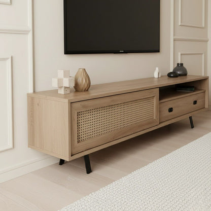 Finn Tv Unit Oak 200cm. Angled shot of the mid-century modern oak media console featuring a faux cane-front sliding cabinet door on the left, an open shelf and drawer with a black handle on the right, and black angled metal legs, beneath a wall-mounted TV.