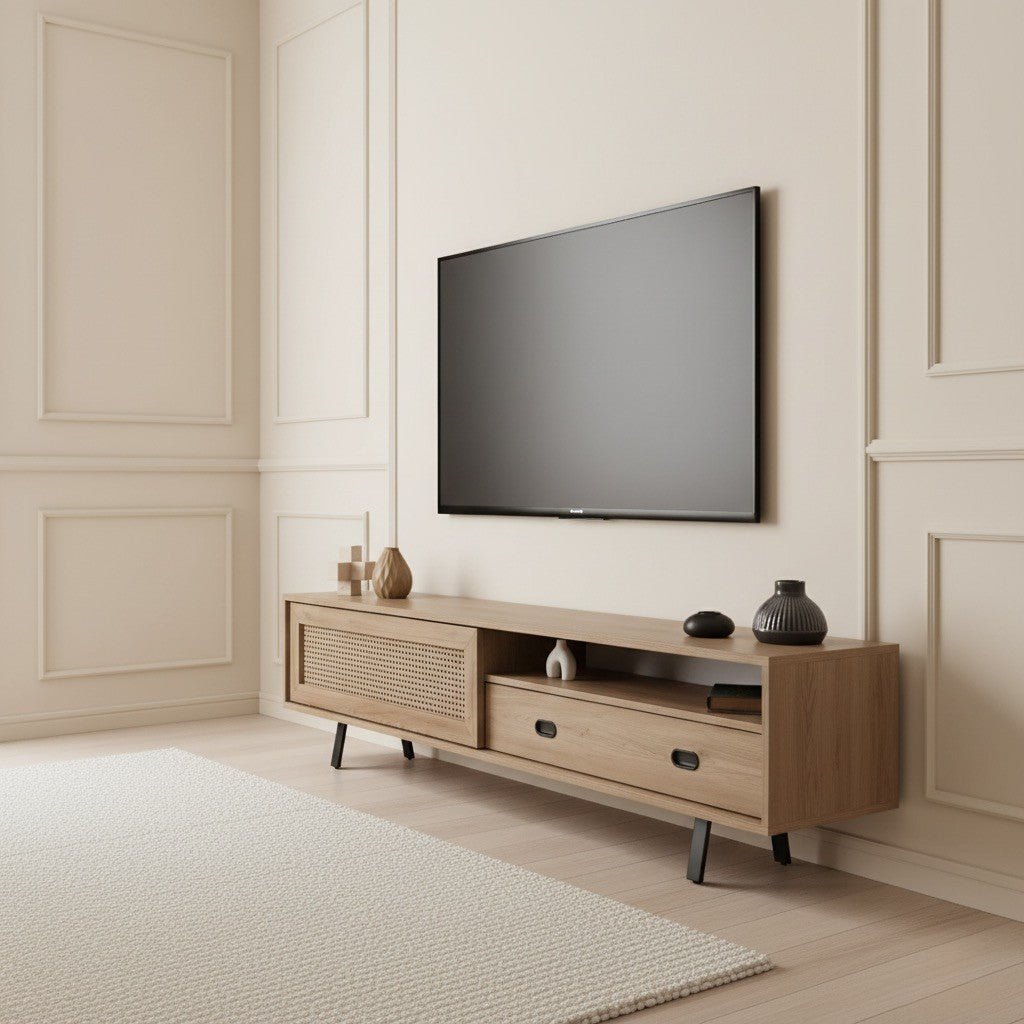 Finn Tv Unit Oak 200cm. Angled view of the mid-century modern oak media console with a faux woven cane-front sliding cabinet door on the left, an open shelf, and a storage drawer with a black handle on the right, supported by black angled legs beneath a wall-mounted TV.