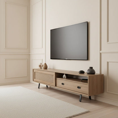 Finn Tv Unit Oak 200cm. Angled view of the mid-century modern oak media console with a faux woven cane-front sliding cabinet door on the left, an open shelf, and a storage drawer with a black handle on the right, supported by black angled legs beneath a wall-mounted TV.