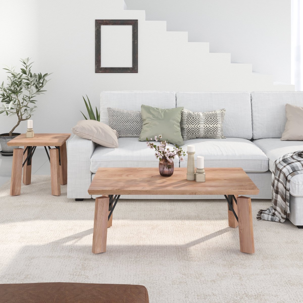 A modern living room scene featuring a light oak coffee table in the foreground, a matching side table on the left, and a white sectional sofa with decorative pillows in the background.