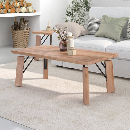 A rectangular wooden coffee table with a natural oak finish and black metal X-brace legs, styled in a bright, modern living room next to a white sofa.