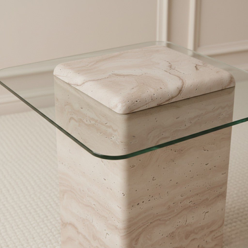 Beige travertine side table with a glass top on a neutral background