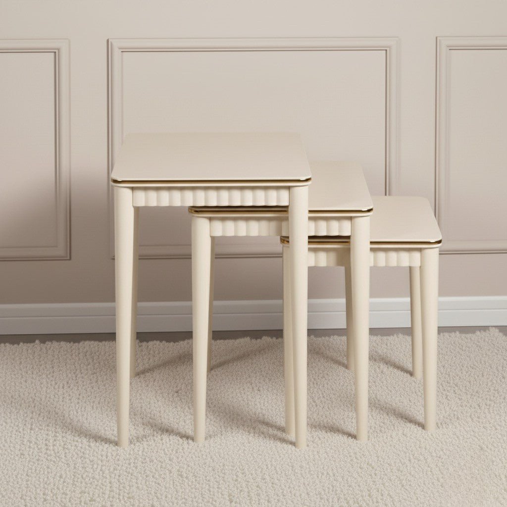 Set of three beige nesting tables against a neutral wall.