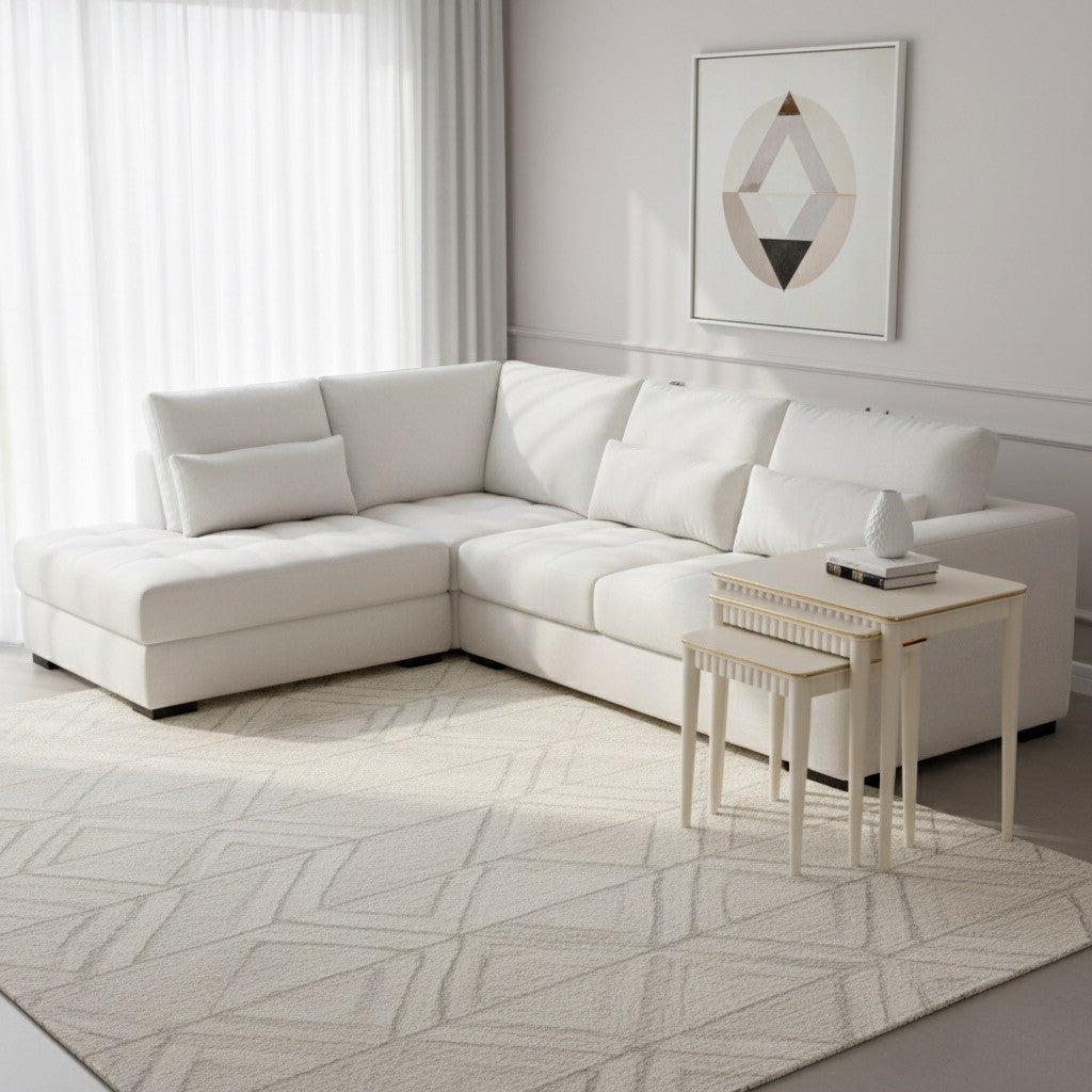 White sectional sofa in a modern living room with a geometric rug and abstract art.