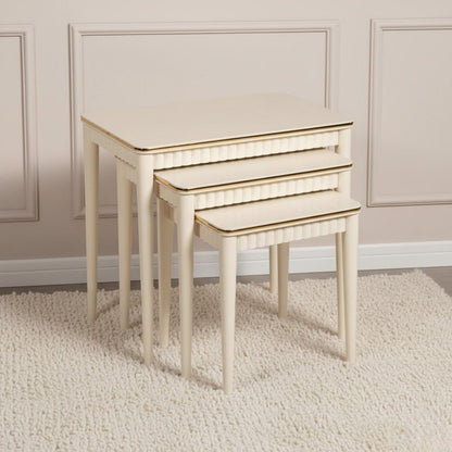 Set of three nesting tables with gold accents on a beige carpet