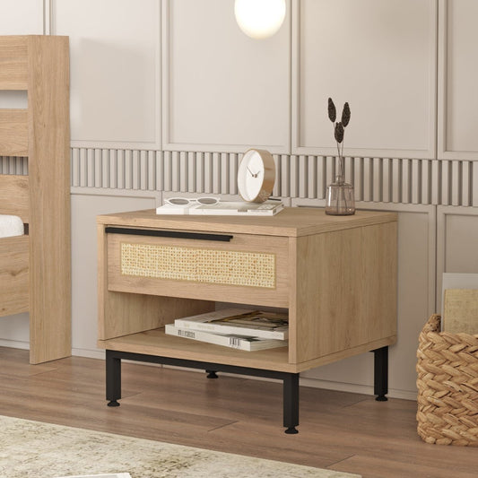 A light oak wood nightstand with a woven cane drawer front and black metal legs, styled in a modern bedroom setting.