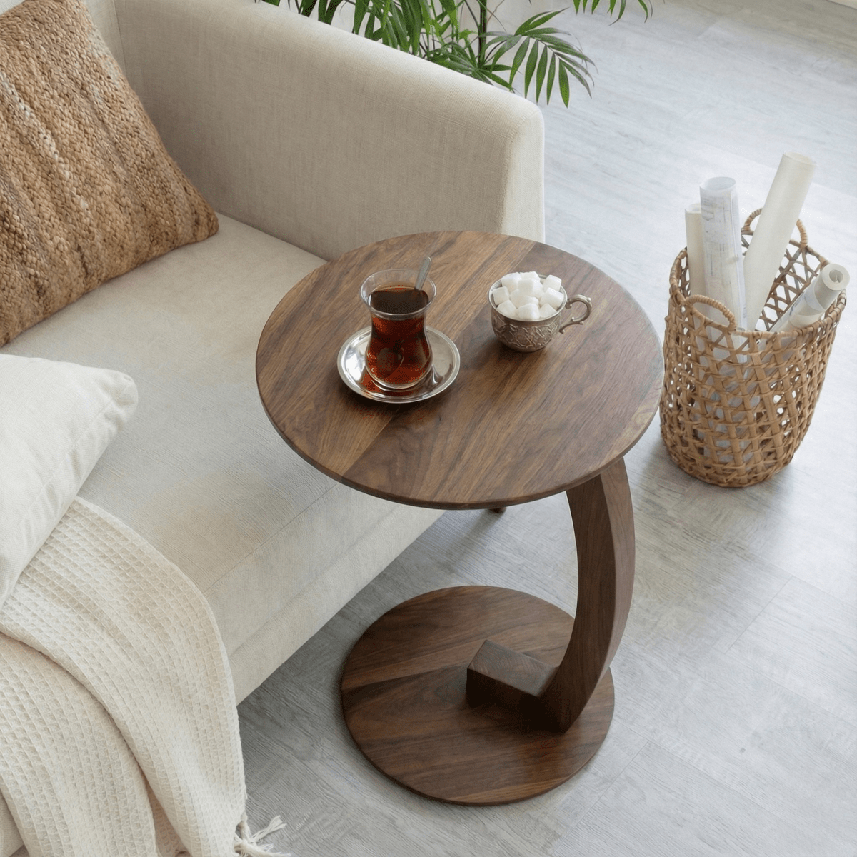 Wooden side table with tea set next to a sofa in a living room