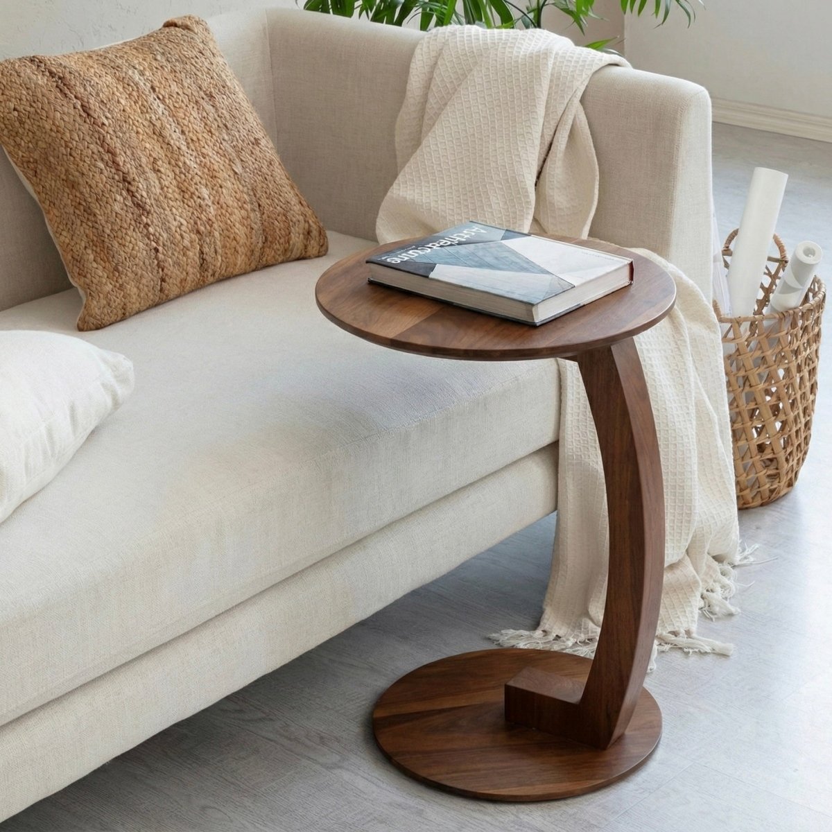 Wooden side table with a book on it next to a beige sofa in a living room.