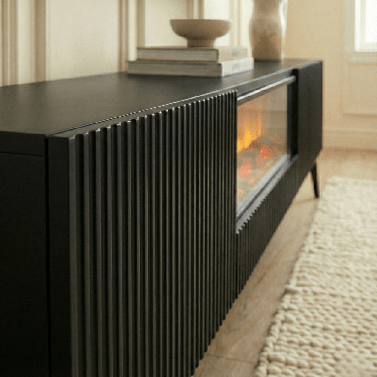 Modern black entertainment console with built-in fireplace in a living room setting.