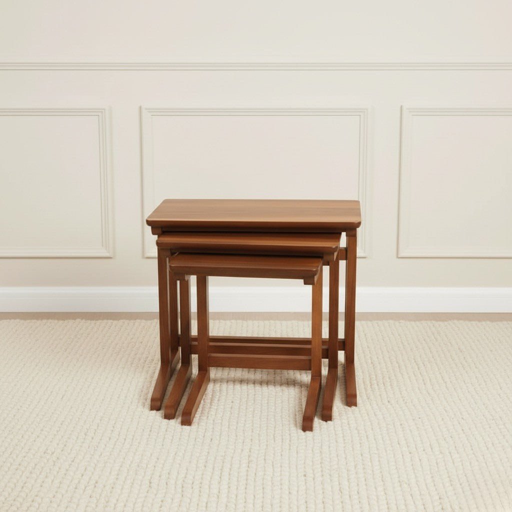 Set of three wooden nesting tables against a neutral wall.