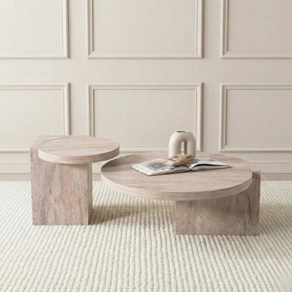 Travertine coffee table with a smaller round side stool against a neutral wall.